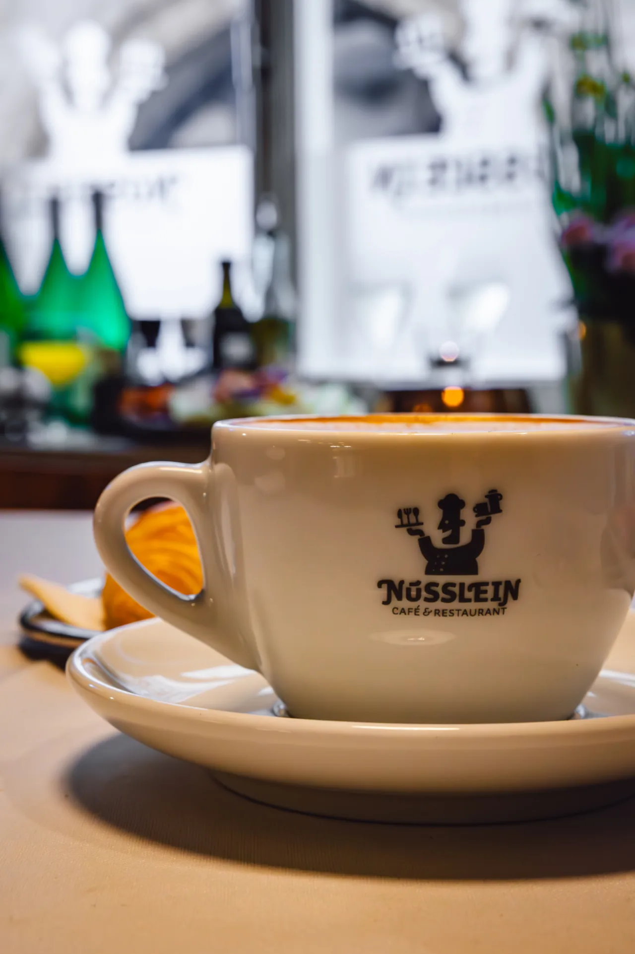 Cappuccino in weißer Tasse mit Nüsslein-Logo im Café an der Krämerbrücke Erfurt